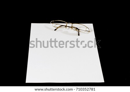 White card on black table. Glasses and pencil. Place to make notes. Black background