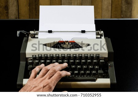 typewriter on the black table. White blank card. Wall of rough boards. black background