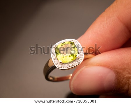 green peridot Jewel gemstone ring on  woman hand put on black background