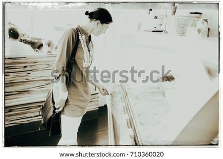 Vintage black and white photo of woman choosing flavours in ice cream shop