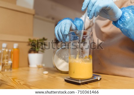 Woman in the process of homemade soap making from organic composition. Shallow depth of field.