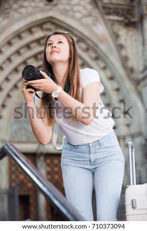 Young woman looking curious and taking pictures outdoors