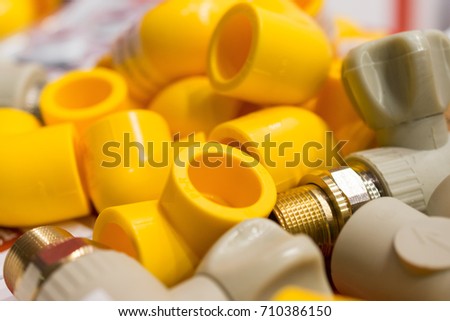 Yellow and gray plastic corners for connecting water pipes.