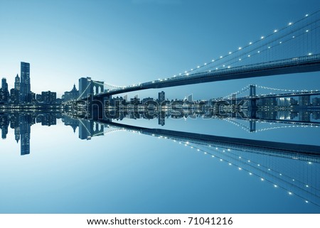 New York City Manhattan skyline and Brooklyn Bridge at dusk with reflection