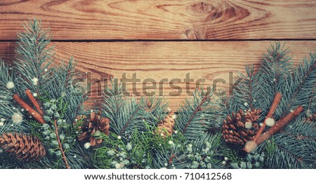 spruce branches on a wooden rustic background, christmas card, frame with place for text, snow effect

