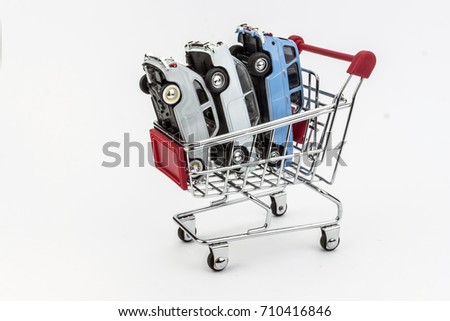 Traditional shopping cart full of miniature cars, business concept
