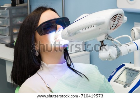 Teeth whitening for woman. Bleaching of the teeth at dentist clinic.  Royalty-Free Stock Photo #710419573