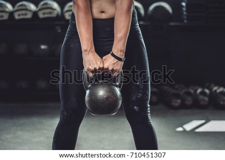 Woman in gym holding a kettlebell. Working Out 