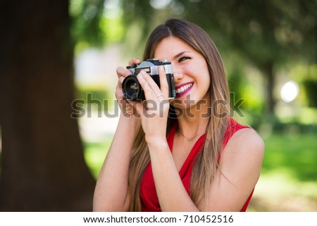 Smiling young woman using a vintage camera