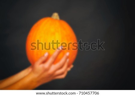 Autumn background with pumpkins and flowers on wooden table. Thanksgiving day concept. Blurred abstract background