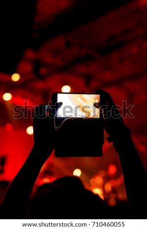 People holding smartphones and taking photo on concert stage