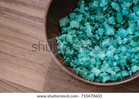 spa salt , blue salt in wooden bowl on wooden background , top view
