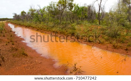 Water puddles on the edge of the sealed road on the Dampier Peninsula  from Broome  to Cape Leveque, North Western Australia on a cloudy late morning in the  December Wet Season after heavy rain.