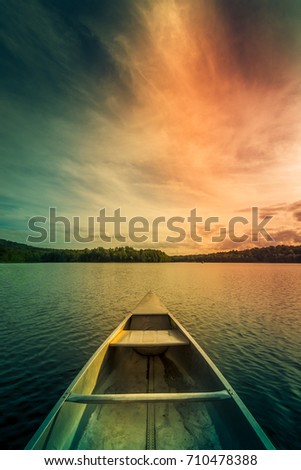 Aluminum canoe on a mountain lake upstate New York. Camping. outdoors and adventure concept.  Faded, vintage color post processed