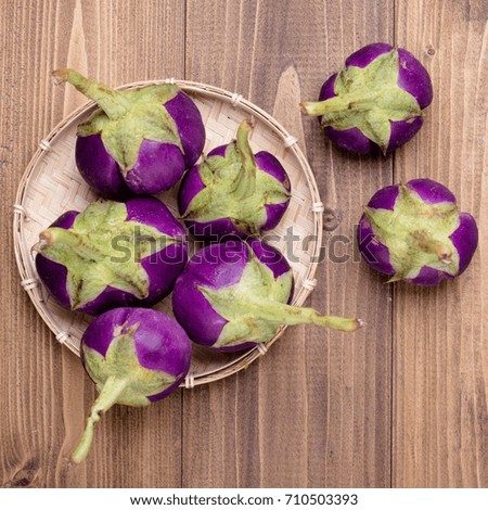 Fresh Thai Purple Eggplants on wood texture background, with bright and clear filter in square format