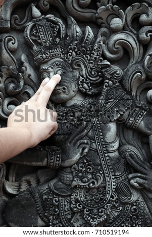 Close up portrait of a typical balinese statue with finger pointing on statue