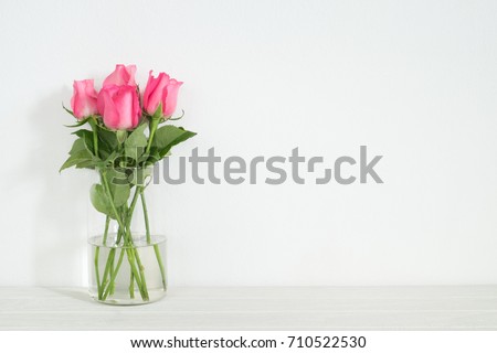 Pink rose in vase on table with copy space