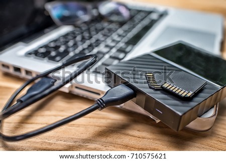 External Hard Disk and Memory Cards on Laptop Keyboard.High Dynamic Range tone Royalty-Free Stock Photo #710575621