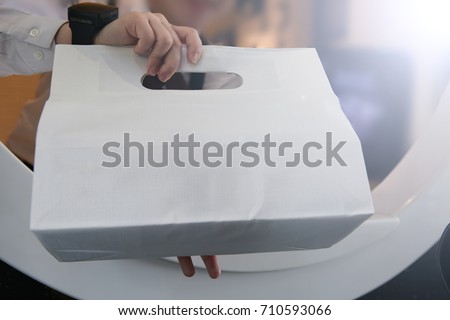 de-focused hand/ The cashier is giving the packaged food. Royalty-Free Stock Photo #710593066