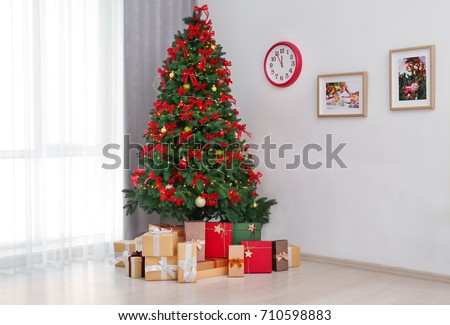Beautiful Christmas tree with gifts in room