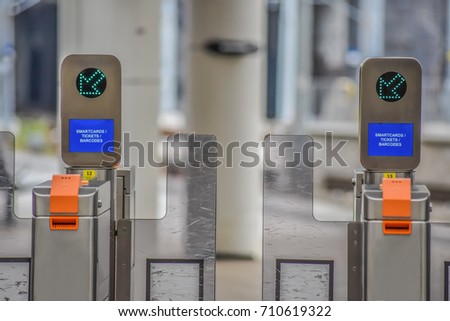Electronic access equipment on entrance gate with green arrow, train station, Manchester, England.