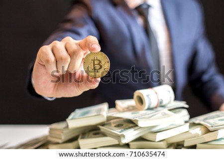 Businessman receive a lot of Money from Smartphone, Businessman Holding Bitcoin Isolated on black background, Digital Money and Bitcoine Concept.