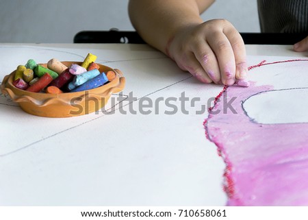 The girl is imagining what her future will be like, artwork is essential for the child, children is working art with chalk color.