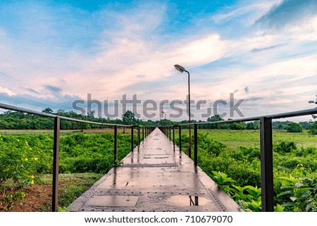 Old steel bridge with street lamp in morning, among nature landscape