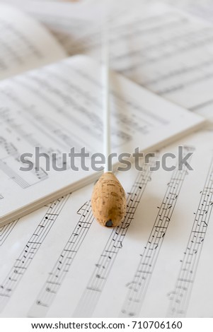 A natural conductors baton on orchestral sheet music Royalty-Free Stock Photo #710706160