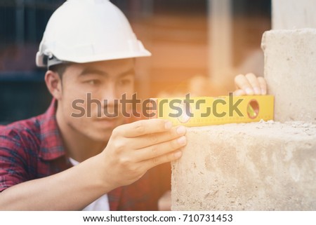 Carpenter in working site using water ruler or gage for measurement on cement