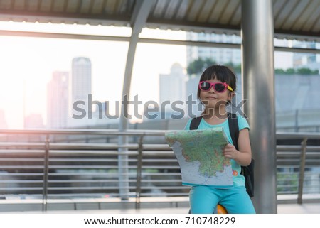 Child with suitcase and city map on summer vacation. Travel and adventure concept
