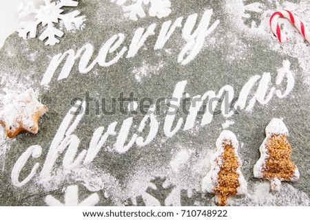 Merry Christmas note written with sugar powder and holiday cookies