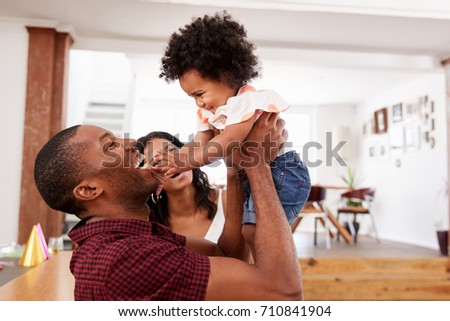 Parents Playing With Young Daughter At Home
