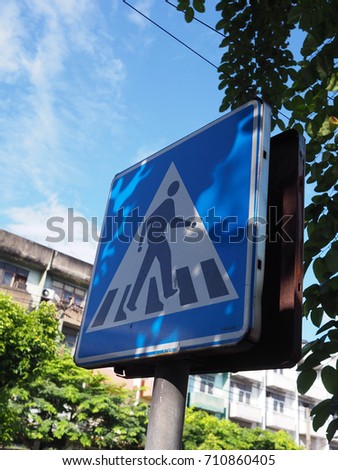 Blue cross road sign with blue sky.