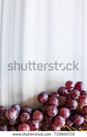Bunches of fresh ripe red grapes on a marble table. Close up. Selective focus
