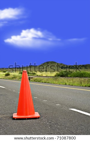 Red cone at roadworks on a tar road