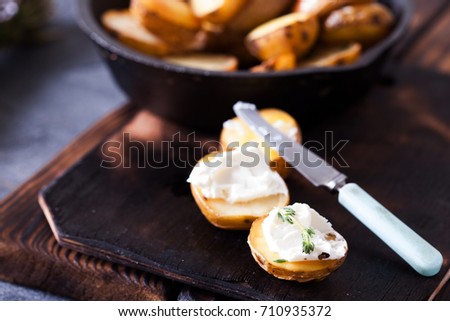 Baked spicy potatoes with soft cheese, closeup