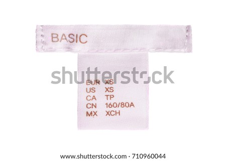 Pink textile clothes label lettered basic on white background