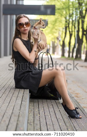 young fashion woman, sitting with her dog on the stairs