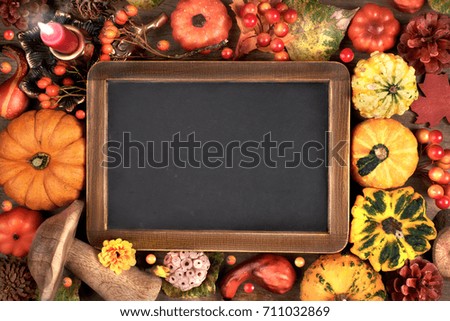 Blackboard framed with Autumn decorations on wood. Top view, toned image, space for your text