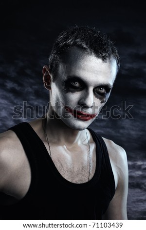Spooky man joker on dark background