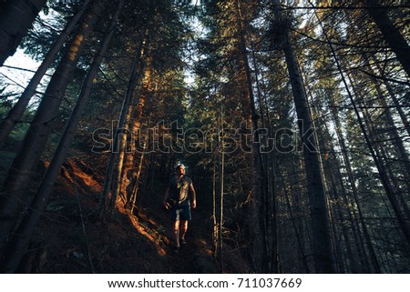 Hiking adventures of alone man photographer in evening forest