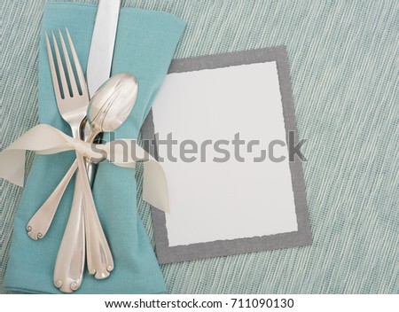 Teal Table Place Setting with Silverware, Cloth Napkin and Textured Turquoise Matt with a Menu Card with room or space for copy, text, or words.  A horizontal with flay lay, top overhead view.