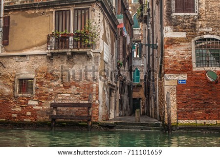 Small Venice canal and lane  the sign on the wall says 'one way' in italian