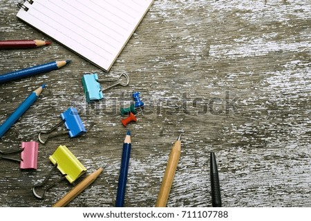 notebook,pencil,pencil color,pin,pen and clip paper on wood ground