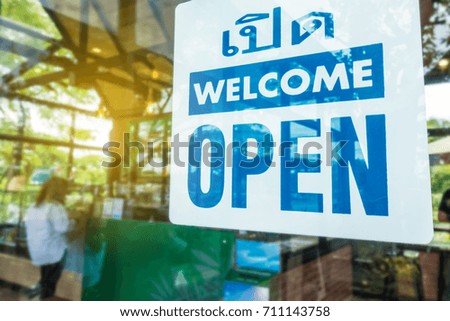 Open sign through the glass of door at cafe. Business and service concept.