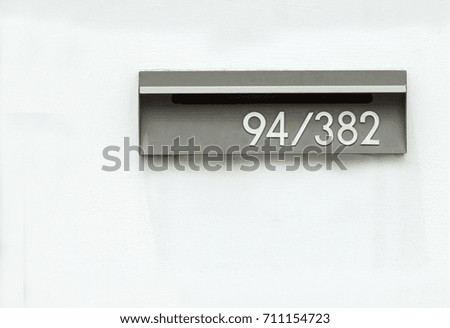 Grey metal mail box install in the wall.Mailbox embedded to the concrete wall ,mail can taking out from the backside.Mailbox with address number 