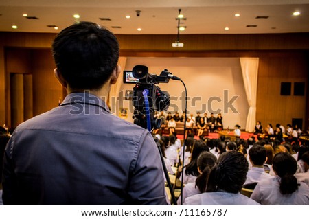 The man recording video of lecturer in the conference hall