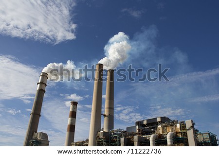 Coal power plant stacks emitting steam into the sky.
