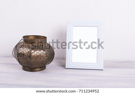 Photo frames next to decorative objects and lavender flower on white and blue wood table. Decor.